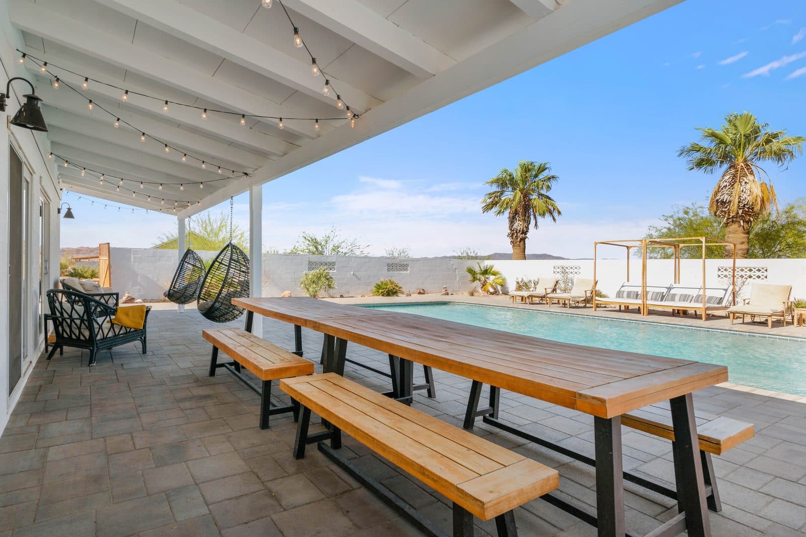 Wonder Valley Ranch — covered patio with string lights overlooking the pool