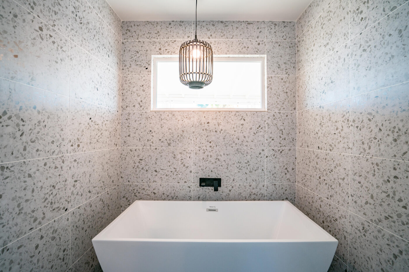 The ADU bathroom, a soaking tub set into terrazzo