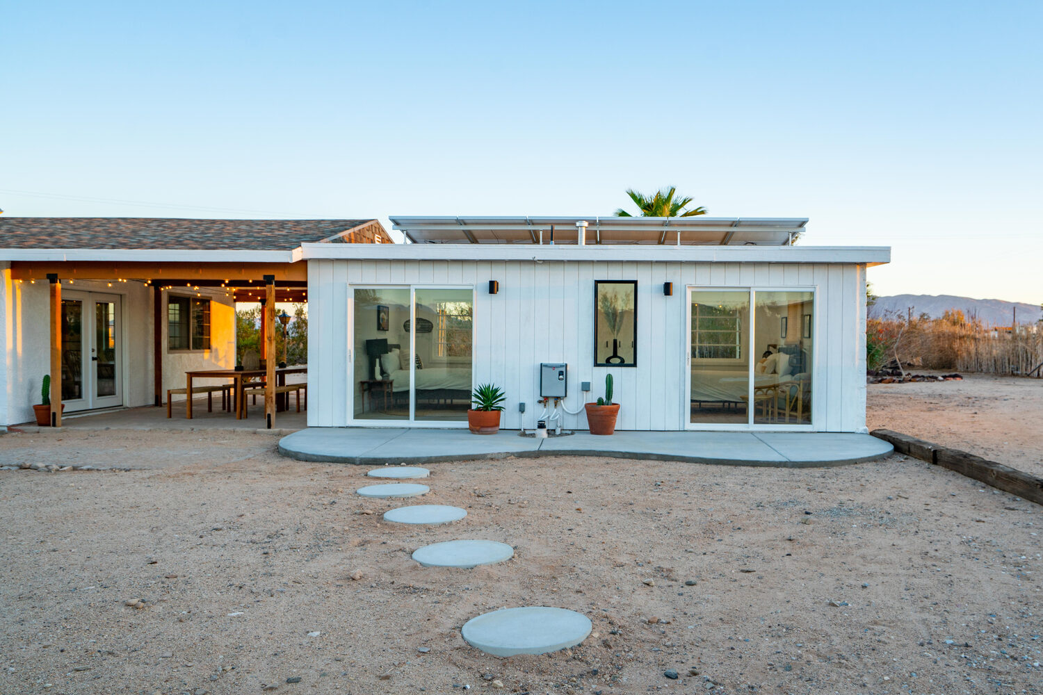 After — the garage building, now the ADU with a concrete patio off the sliders